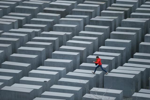 BERLIN, GERMANY - OCTOBER 28: A boy hops from one to another of the 2,711 stellae at the Memorial to the Murdered Jews of Europe, also called the Holocaust Memorial, on October 28, 2013 in Berlin, Germany. The monument, located in the city center, was designed by American architect Peter Eisenman and commemorates the 6 million Jews murdered by the Nazis. (Photo by Sean Gallup/Getty Images)